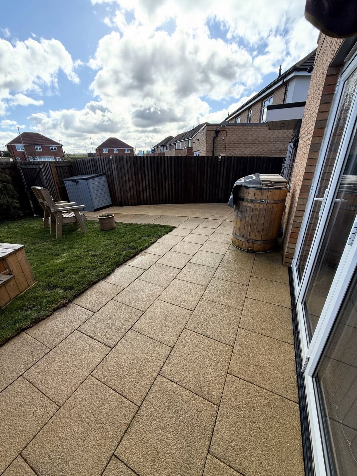 Clean buff patio flags beside a lawn and hot tub